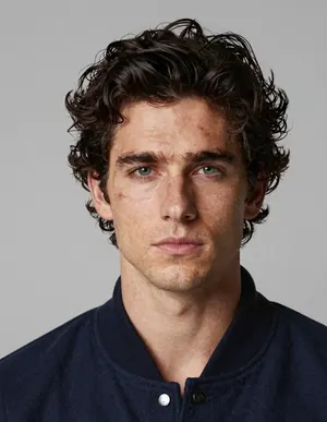 Candidate face 3: another take on the same character, curly dark hair and a navy jacket